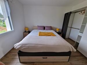 a bedroom with a large bed with purple pillows at Cœur de village commerces proximité Center Parcs in Les-Trois-Moutiers