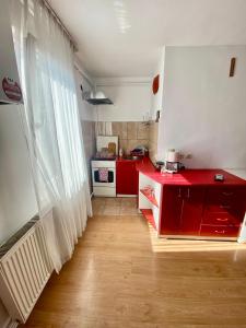 a kitchen with red cabinets and a red counter top at Eden Apartament in Reghin