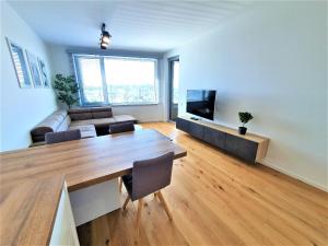 a living room with a couch and a table and a television at Prestigious SKY PARK apartment - City view - Traveller awards 2024 in Bratislava