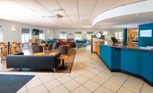 a lobby with a bar and a restaurant at Holiday Inn Express Gloucester - South, an IHG Hotel in Gloucester