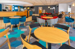 einen Wartebereich mit Tischen und Stühlen in einer Cafeteria in der Unterkunft Holiday Inn Express Gloucester - South by IHG in Gloucester