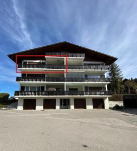 um grande edifício com um parque de estacionamento em frente em Mountain Horizon em Schwarzsee