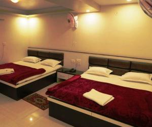 1 dormitorio con 2 camas con sábanas rojas y almohadas blancas en Venus Hotel 5 Minute Walking Distance from Dargah, en Ajmer