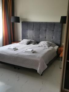 een slaapkamer met een groot bed en 2 handdoeken bij Apartament prywatny z aneksem kuchennym w hotelu Royal Tulip Sand in Kołobrzeg
