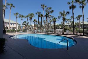 a swimming pool with palm trees in a resort at Crystal Dunes by Panhandle Getaways in Destin
