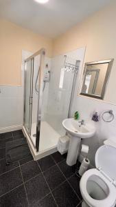 een badkamer met een douche, een toilet en een wastafel bij The Cabbage Hall Hotel in Liverpool