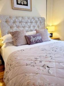 a bedroom with a large bed with a headboard and pillows at Apartment 1 Exquisite two king bedroom with en suites - close to the town centre, rail, airport and theatre in Darlington