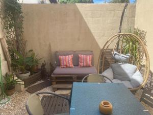 a patio with a chair and a bench with pillows at Chez Berthe in Arles