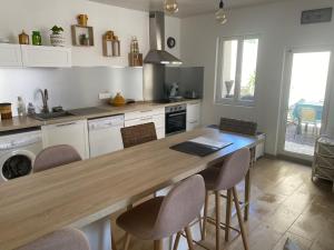 a kitchen with a wooden table and chairs in it at Chez Berthe in Arles +3 photos