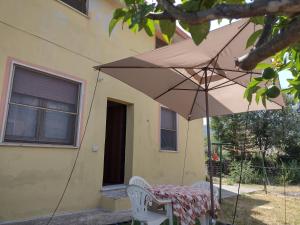 Sa domu de Peppinu في كاربونيا: طاولة مع مظلة أمام المنزل