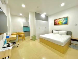 a bedroom with a bed and a table and a kitchen at Chanh Huy Apartments & Hotel in Ho Chi Minh City