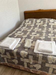 a bed with a quilt with two towels on it at Sevan’s flat in Sevan