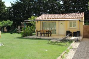 a small yellow house with a table and chairs in a yard at Le Gîte du Moulin in Sarrians