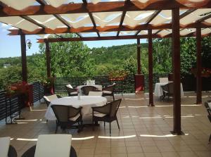patio ze stołami i krzesłami pod pergolą w obiekcie Vila Bucium Club w Jassach