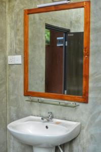 y baño con lavabo y espejo. en Pidurangala View Treehouse, en Sigiriya