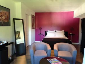 サン・ジュニアンにあるLes Chambres Lauryvanのベッド1台と椅子2脚が備わるホテルルームです。