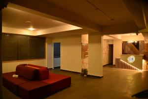 a living room with a red couch in a room at Hotel V M Comfort in Bangalore