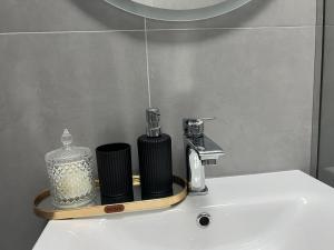 un lavandino del bagno con un distributore di sapone sopra di Pretty Home Kaonet a Orikum Altre 30 foto