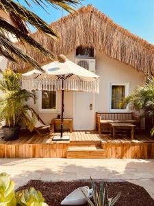 a house with a wooden deck with an umbrella at Kalia Beach Hotel Side in Side