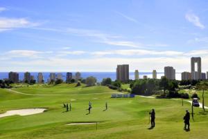 um grupo de pessoas a jogar golfe num campo de golfe em Luxury apartment Residencial Sunset Drive - Benidorm, España em Benidorm