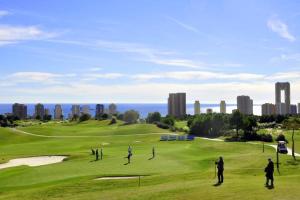 a group of people playing golf on a golf course at Luxury apartment Residencial Sunset Drive - Benidorm, España in Benidorm