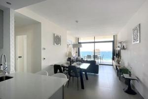a kitchen and living room with a table and chairs at Luxury apartment Residencial Sunset Drive - Benidorm, España in Benidorm