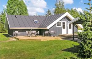 a house with a deck with chairs and a table at Amazing Home In rsted With 3 Bedrooms, Sauna And Wifi in Kare