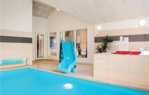 a pool in a room with a blue slide at 6 Bedroom Beautiful Home In Tranekr in Hou