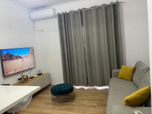 un soggiorno con divano e TV a schermo piatto di Pretty Home Kaonet a Orikum