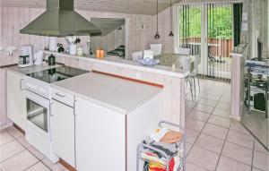 cocina con encimeras blancas y fogones en Cozy Home In Grenaa With Wifi, en Stokkebro