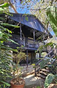 ein Haus mit einem blauen Dach mit einer Treppe in der Unterkunft Old Vic Travellers Inn Nelspruit in Nelspruit