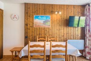 - une salle à manger avec une table et des chaises dans l'établissement Le Balcon d'Ancelle - Appt vue montagne, à Ancelle