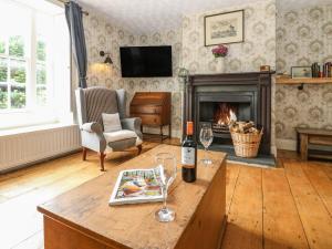a living room with a bottle of wine and a fireplace at Prudhoe Cottage in Prudhoe
