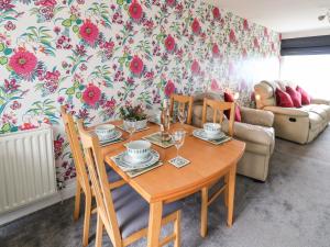 comedor con mesa de madera y sillas en Sea View Cottage, en South Shields