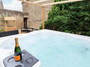 a bottle of champagne sitting in a hot tub at Prudhoe Cottage in Prudhoe