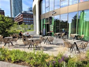 a patio with tables and chairs in front of a building at Prestigious SKY PARK apartment - City view - Traveller awards 2024 in Bratislava