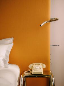un teléfono en una mesita de noche junto a una cama en Hotel Josef en Praga