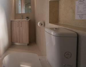 a bathroom with a white toilet and a sink at Phaedrus Living: Peristerona Traditional Maisonette in Peristerona