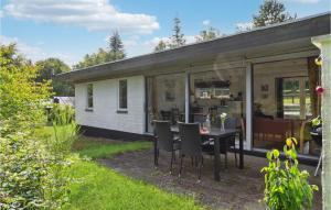 een huis met een tafel en stoelen in de tuin bij 2 Bedroom Amazing Home In Allingbro in Allingåbro