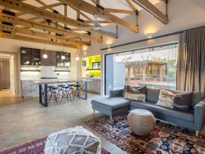 a living room with a couch and a table and a kitchen at Lavish villa in Hoedspruit with hot tub in Hoedspruit