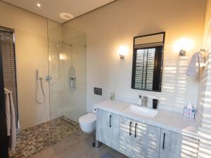 a bathroom with a sink and a toilet and a shower at Lavish villa in Hoedspruit with hot tub in Hoedspruit +20 photos