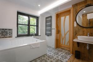 ein Badezimmer mit einer Badewanne und einem Waschbecken in der Unterkunft Dom w Starym Parku in Biskupice