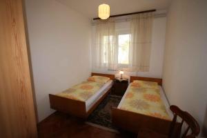 two beds in a small room with a window at Apartment in Silo/Insel Krk 14533 in Šilo