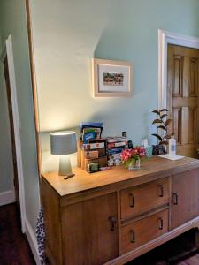 a room with a wooden dresser with a lamp on it at McCrae's Bed and Breakfast in Edinburgh