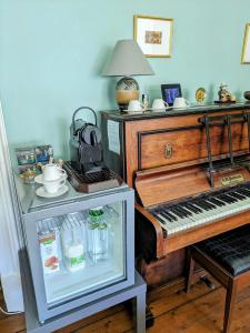 un viejo piano sentado junto a una mesa junto a una mesa con una mesa en McCrae's Bed and Breakfast, en Edimburgo