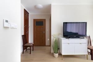 シフィノウイシチェにあるApartamenty przy Promenadzie Villa Mistral II by Rentersの白いキャビネット上のテレビ付きのリビングルーム