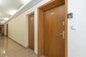 a hallway with a wooden door in a building at Apartamenty przy Promenadzie Villa Mistral II by Renters in Świnoujście