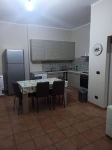 uma cozinha com uma mesa e cadeiras e um frigorífico em Casa vacanze palagianello em Palagianello