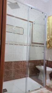 um chuveiro com uma porta de vidro na casa de banho em Casa vacanze palagianello em Palagianello