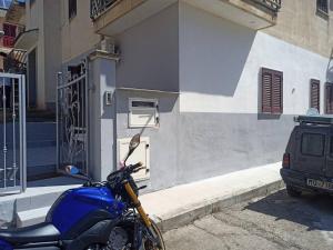uma moto azul estacionada em frente a um edifício em Casa vacanze palagianello em Palagianello